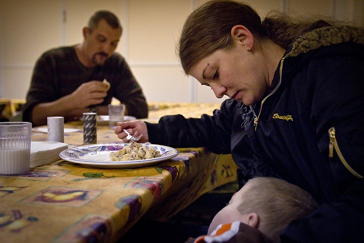 &lt;p&gt;Brandy Achziger sits down to enjoy a meal with her husband Adam as one of her two sons sleeps on her lap Thursday.&lt;/p&gt;