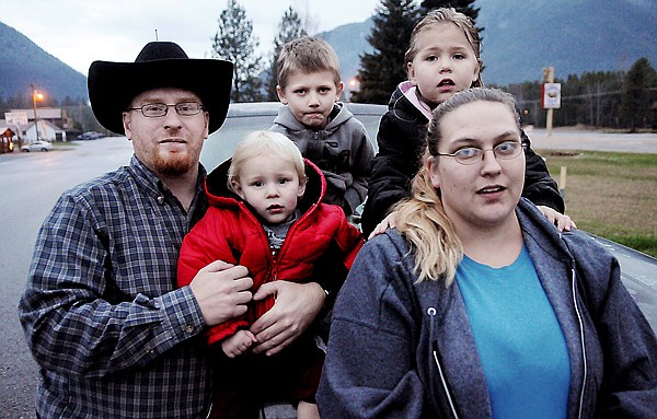 Thanks to training from his parents, 6-year-old Kyle Johnson, gray sweatshirt, was able to call for help when his mother, Debra Johnson, right, passed out in the car in Hungry Horse last week. Kyle, his 2-year-old brother Roy, and sister Virginia, 4, were in the vehicle at the time. Kyle called his stepfather, Michael Spencer, left, and told him where to find them.