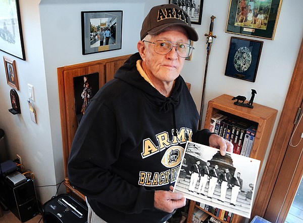 &lt;p&gt;David Hadly holds a photo of himself, center, and some of his
West Point classmates.&lt;/p&gt;