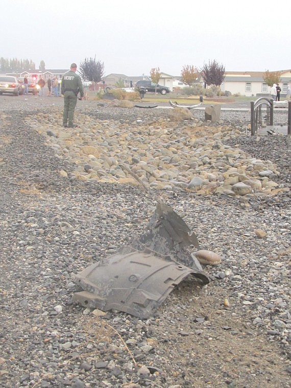 The force of a Friday afternoon roll-over at Desert Aire was
enough to snap off a wheel and leave the 2006 Infiniti totaled. One
passerby seems to point out the path of the flipping, spinning car
to another bystander.