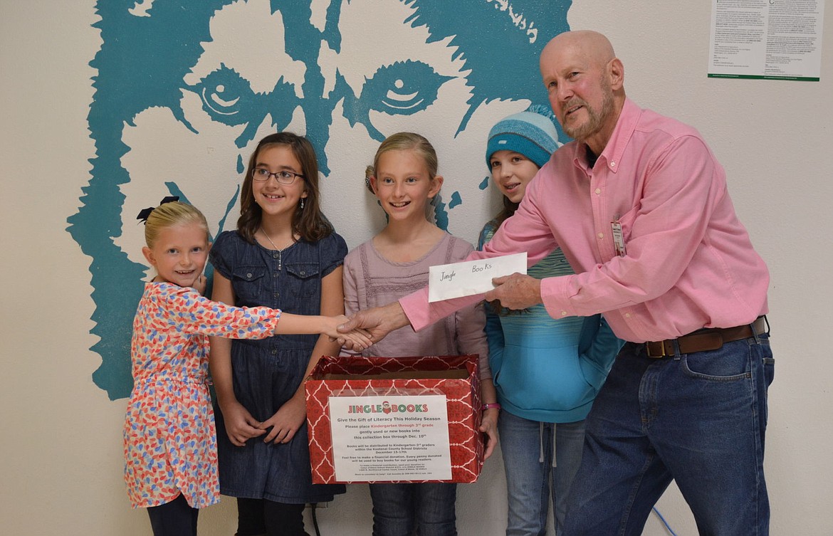 &lt;p&gt;Coeur d&#146;Alene School District Trustee Dave Eubanks accepts a $90 donation from four girls who sold lemonade to raise the money for the Jingle Books program. From left: Ashley Yates, Annalie Terzulli, Ava Yates and Ella Terzulli.&lt;/p&gt;