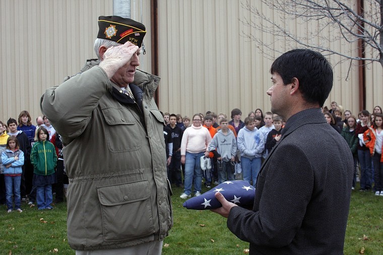 VFW Post 3596 Commander James Gillibrand presents the retired flag to Plains School Superintendent Thom Chisholm.