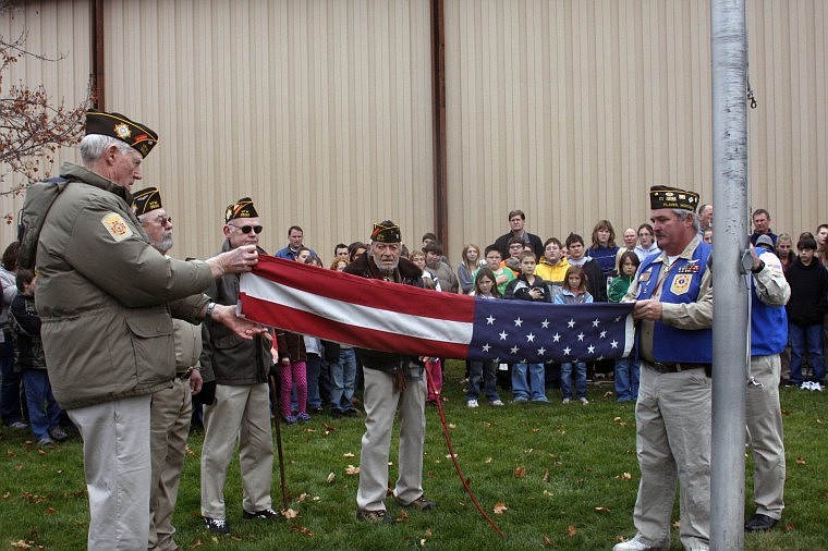 Commander James Gillibrand and Greg Davis fold the retired flag.