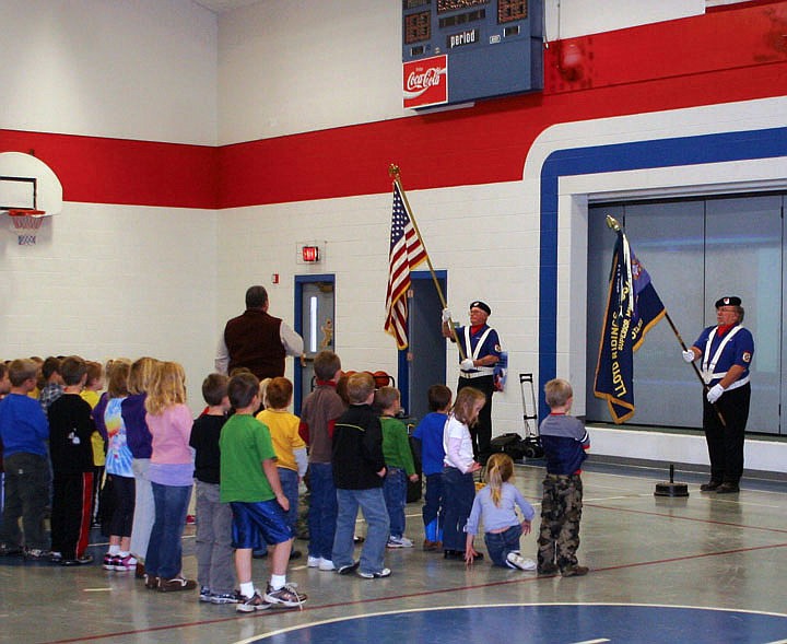 Students watch as Doug Cummings and HF Berneking place the colors during the assembly at Superior Elementary on Veteran's Day.