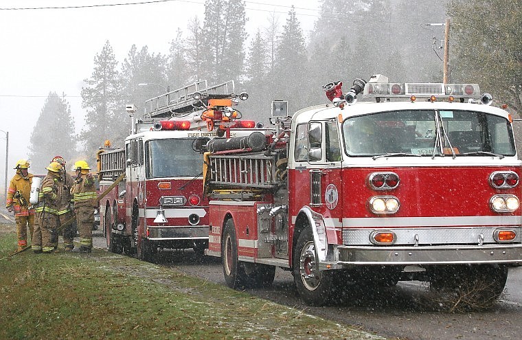 &lt;p&gt;Plains city firemen congregate shortly after putting out the
basement fire as a snowstorm approaches.&lt;/p&gt;