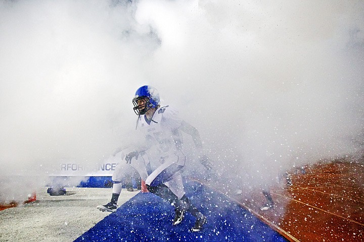 &lt;p&gt;JEROME A. POLLOS/Press Coeur d'Alene High's Cody Schneider races through the fog created by fire extinguishers shot off to mark the Viking's entrance into the 5A State Championship football game Friday against Eagle High at Bronco Stadium in Boise.&lt;/p&gt;