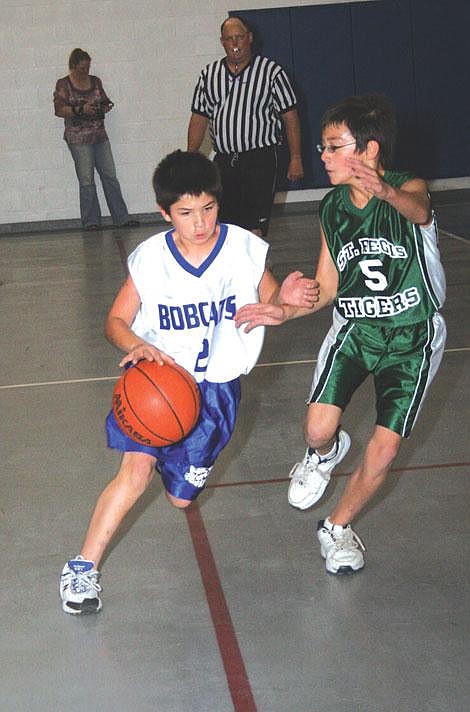 Nick Ianniello/Mineral Independent Superior Bobcat Vincente Guerro sneaks past St. Regis Tiger Andrew Managhan during a junior high basketball game in Superior Friday evening. The Bobcats and Tigers played two games, with the Tigers coming out on top in each.