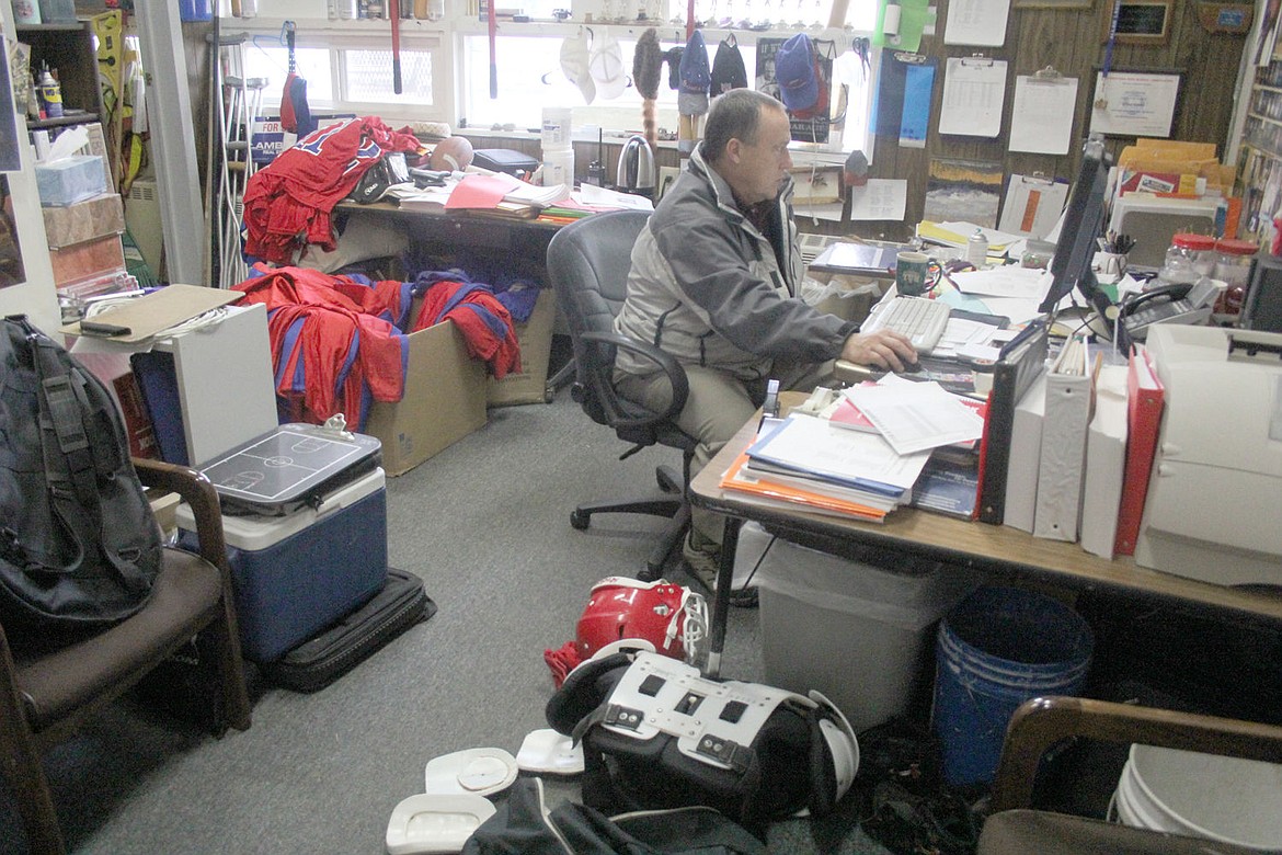 <p>Superior High School Principal and Athletic Director Allan Labbe work in his office surrounded by football gear. Labbe recently announced he was stepping down as head football coach.</p>