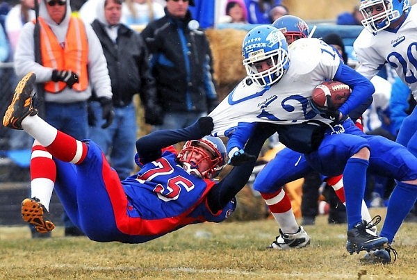 Bigfork's Jessie Kelso (75) keeps his arm glued to the jersey of Fairfield's Trace Brady (12) in the second half of Saturday's Class B Championship Game in Bigfork.