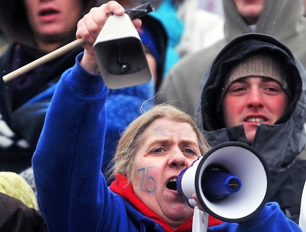 Deanna Kelso shakes a cowbell and calls through a megaphone from the stands.