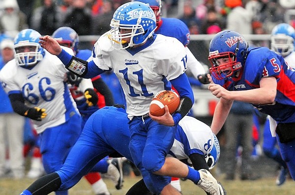 Fairfield Quarteback Trace Brady (11) carries the ball with Bigfork's Connor Coleman (45) on his tail.