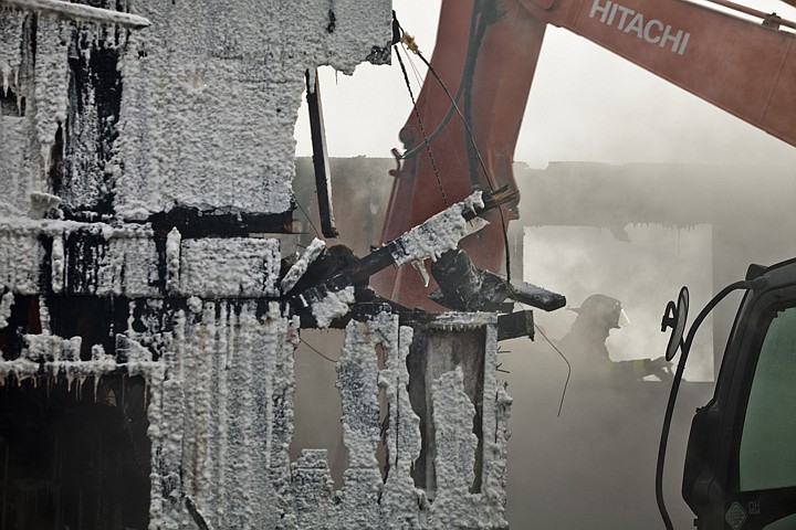 &lt;p&gt;Joe Testa of the Badrock Fire Department sprays water as an
excavator works to expose hot spots in the basement of a two-story
house that burned Wednesday morning.&lt;/p&gt;