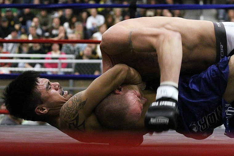 Arlee's Louie Moses ties up Tracy Sanford while getting punched in the side in the center of the ring.