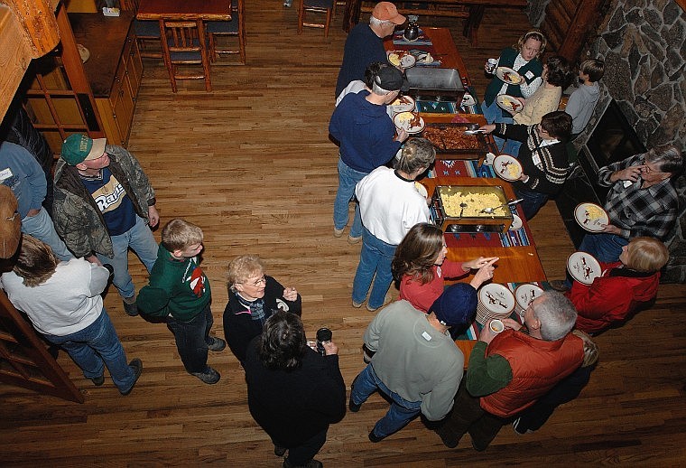 More than 100 &#147;elves&#148; received breakfast at the Flathead Lake Lodge before splitting into two groups. One group stayed at the lodge to assemble Christmas light bulbs and the other headed outdoors to cut down trees.