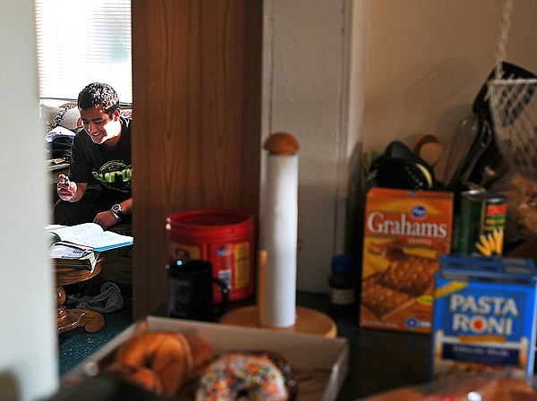 Chris works on his homework on the living room couch at a Ray of Hope.