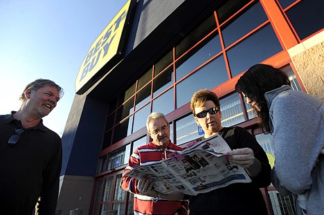 &lt;p&gt;From left, Mark Pugh, Frankie and Pam Davis, and Jamie Pugh look over the discounts that await them when Best Buy's doors open at midnight, at the Wards Crossing Shopping Center in Lynchburg, Va., Thursday. Mark Pugh was first in line at Best Buy, arriving at 5:15 a.m., beating the next arrivals by about 15 minutes.&lt;/p&gt;