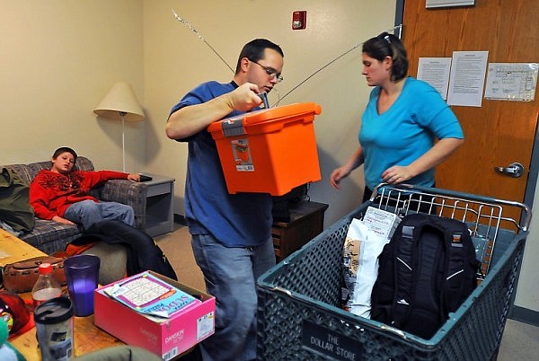 The family uses a shopping cart to pack up their belongings at their apartment at Samaritan House.