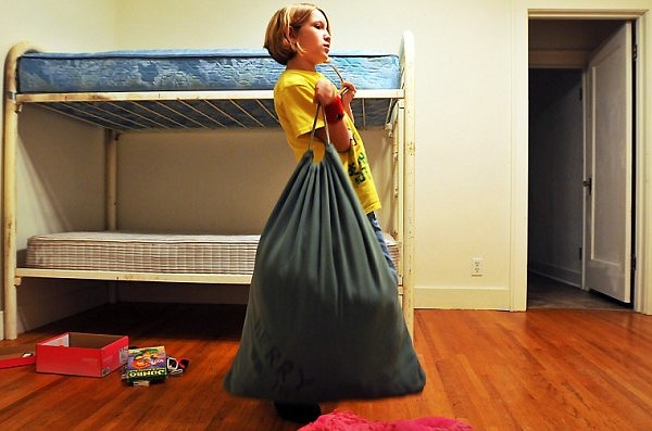 Alena, 9, sets down a bag full of clothes to unpack in her new room.