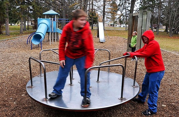 Robert gets spun by William on the merry-go-round at Woodland Park.