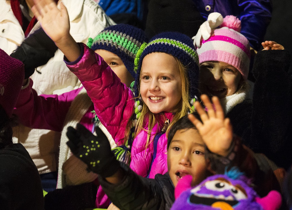 &lt;p&gt;Lily Bole, 9, center, waves to Santa Claus as he makes his way down Sherman Avenue during the holiday parade preceding the Coeur d'Alene Resort Holiday Light Show Friday night.&lt;/p&gt;