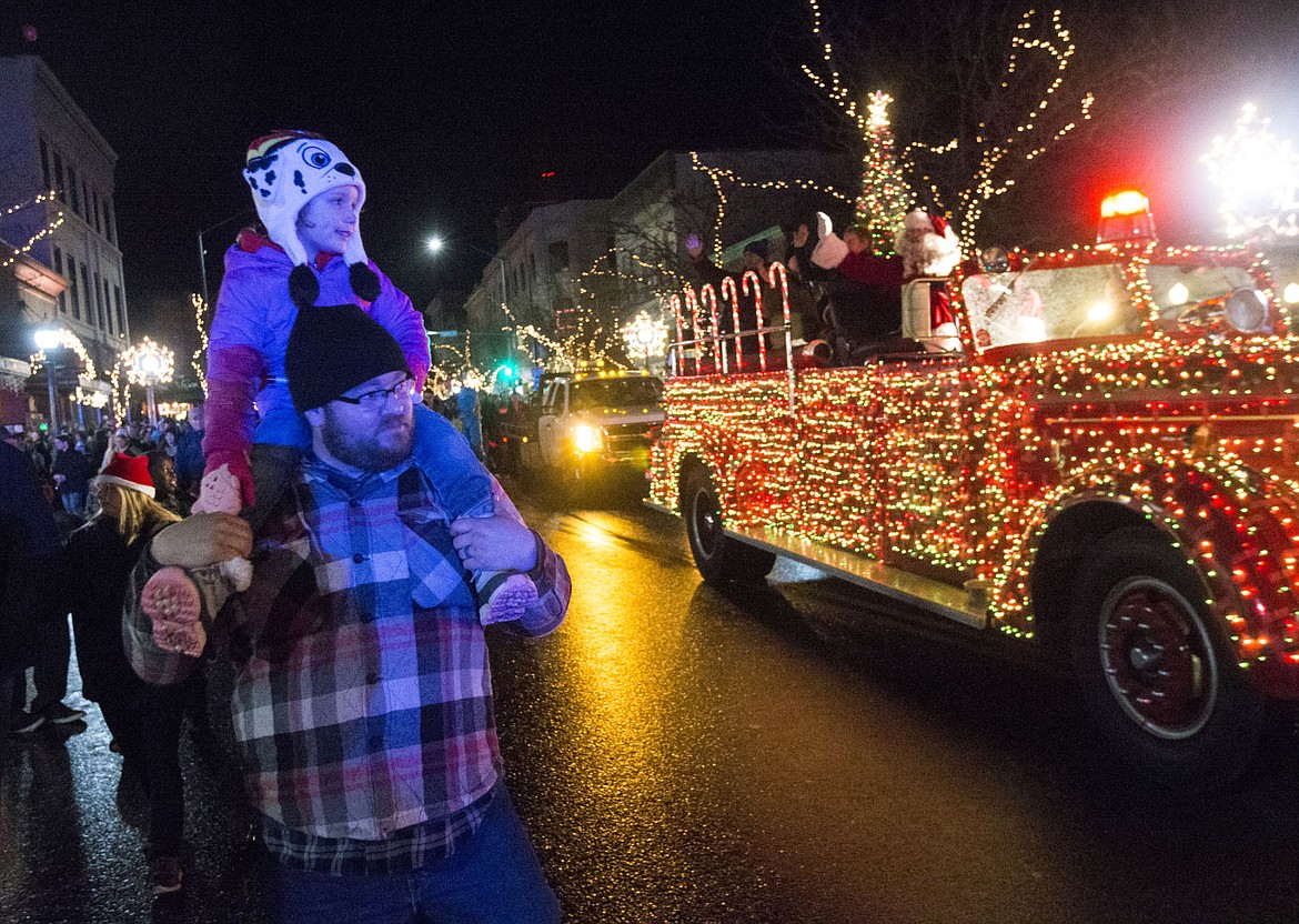 &lt;p&gt;James Parker holds his 4-year-old daughter, Abby, as they follow Santa Clause down the holiday parade route Friday night.&lt;/p&gt;