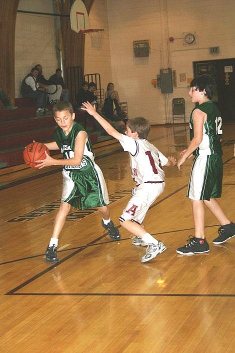 Nick Ianniello/Mineral Independent St. Regis Tiger Shad Rich sets up to pass around Alberton Panther David Stafford during a game in Alberton last Tuesday evening. The Panthers won this game but the Tigers came out on top in an earlier match-up.