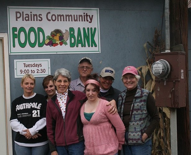 The Plains Community Food Bank's volunteer staff pose in front of their new sign. From left to right: Shannon Allen, Serena Bauer, Mary Jane Seigford, Dennis Ovitt, Nina Lane, Deb Warren and Mabel Cook.