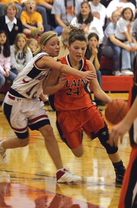 Jennifer McBride/Valley Press Felicia Earhart drives past Hot Springs player Laurel Schmiedbauer at the junior high basketball trounament held in Hot Springs last weekend.