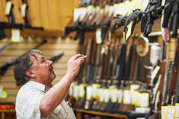 &lt;p&gt;Firearm salesman Bill Archie looks over the AR-type rifles Monday evening at Snappy's Sports Senter.&lt;/p&gt;