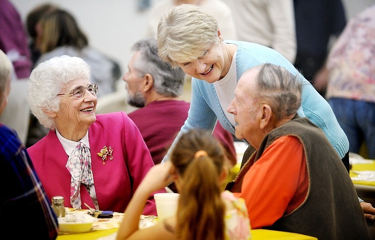 Karen Breck of Kalispell, center, stops to talk with Doug and Judy Wise at the Community Thanksgiving Dinner.