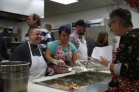 &lt;p&gt;Tony Holmes of Coeur d&#146;Alene, left, shares a smile with Zooey Byram of Coeur d&#146;Alene as Mary Ekstedt of Coeur d&#146;Alene serves stuffing and creamed spinach during the free community Thanksgiving Day meal at the Lake City Center.&lt;/p&gt;