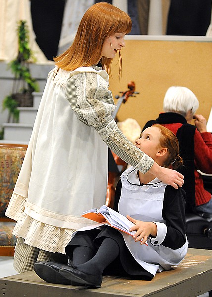 Madison, 10, center, one of the scene shifters, helps her sister Rachel, 15, by reading the part of Colin Craven, during rehearsal on Wednesday night. 
The whole Wambeke family is taking part in the Whitefish Theater production of the Secret Garden which will open December 3rd and run through the 19th.