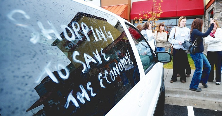 The Shop &#146;til ya Drop women, a group of loyal Black Friday shoppers from Canada, visit with one another in front of one of their decorated vehicles Friday in Kalispell. The women took a break from their shop-a-thon for brunch at Sizzler before heading back into the busy stores.