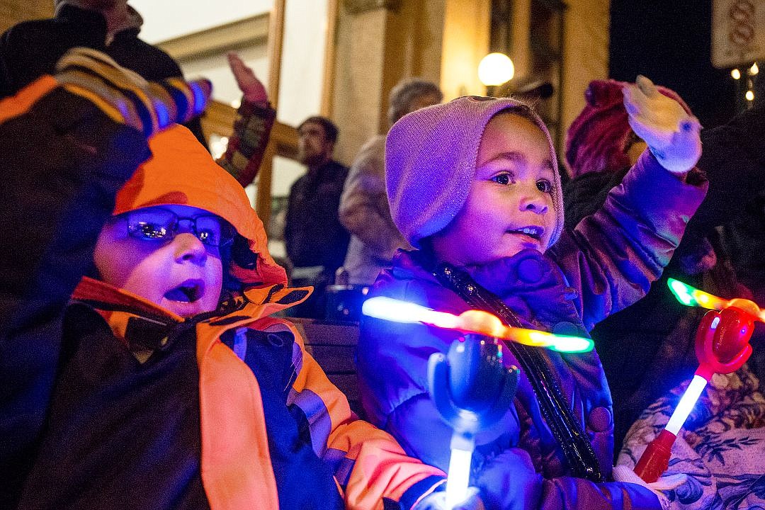 &lt;p&gt;Bundled up against the 20-degree chill, Cameron Hirth, left, and Laeyla Brooks, both 3, hold light-up toys and wave at passing parade floats on Friday at the annual holiday parade preceding the 29th Annual Coeur d'Alene Resort Holiday Light Show on Sherman Avenue in Coeur d'Alene.&lt;/p&gt;