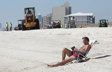 &lt;p&gt;Dick MacDonald of Prince Edward Island, Canada suns on the beach near oil spill cleanup work in Orange Beach, Ala., on Nov. 9.&lt;/p&gt;