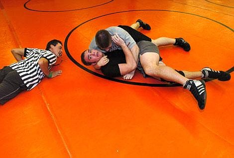 Referee Lance ZandeR watches closely as Flathead seniors Mark Svenson (black T-shirt) and Justin Waverek compete in Tuesday&#146;s Wrestle-Offs at Flathead High School. Svenson decisioned Waverek 6-5 in the 215-pound weight class. Jennifer DeMonte/Daily Inter Lake