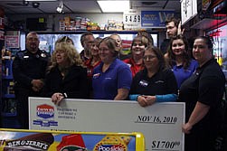 Employees of the Plains Town Pump, accompanied by Plains Police Chief Shawn Emmett, accept a reward check from the &quot;Unstung Heroes&quot; program.