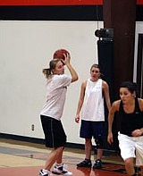 In a drill at practice, Ashley Holmes snags a rebound while Diamond Ladeaux cuts to an open spot on the floor for a jump-shot and Kelsi Beagley watches from the sideline.