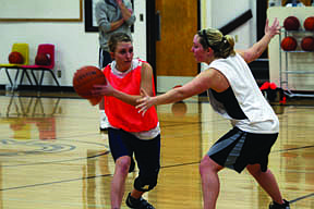 Kelsi Beagley tries to wrap a pass around the stingy defense played by Nikki Kunzer.
