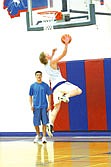 Tanner Coon goes up for a layup at practice while Daylon Kuhl watches.