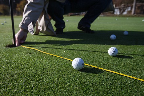 &lt;p&gt;GABE GREEN/Press The distance from the $1,000 golf ball, belonging to the Cranney family, to the tee is measured Saturday at the Avondale Golf Club driving range, setting it only inches away from surrounding balls. 700 golf balls were dropped from a Helicopter flown by Jim VanSky of Big Sky Helicopter Services as part of a fundraiser for the Coeur d&#146;Alene Charter Academy&#146;s music program. Each ball was purchased for $10 by community members and whichever ball landed closest to the tee won its owner $1,000 in visa gift cards. The program collected a total of $6,575 from the fundraiser.&lt;/p&gt;