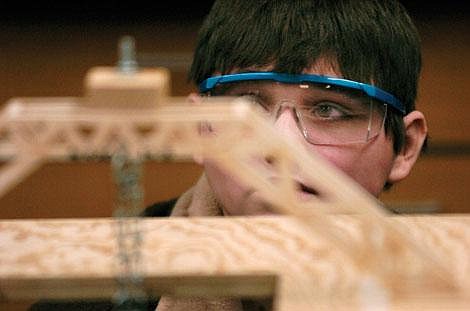 Kelly Gorham/courtesy photo Noxon seventh grader John Onofrey studies the integrity of hid bridge as he adds the final amount of weight Tuesday during the elevated bridge event at the Montana Science Olympiad at Montana State University. Onofrey's bridge supported a full 15 kilograms (33 pounds) without breaking.