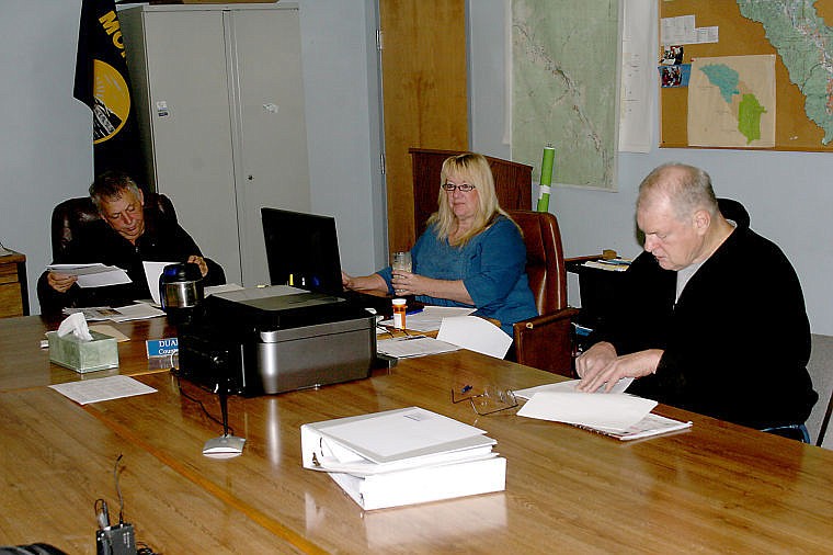 &lt;p&gt;County Commissioner Duane Simmons, Cindy Grimm and Dennis Hildebrand look over a series of letters to be delivered to the Forest Service. The letters were composed by MCRAG and addressed the commissioner's concerns about the West Mullan Fire cleanup and the Cedar Thom project.&lt;/p&gt;