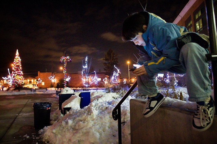 &lt;p&gt;Scotty Hoffer, 12, checks his cell phone after the crowd cleared Friday night following the tree lighting ceremony at the Post Falls City Hall campus during the city's Winterfest event.&lt;/p&gt;