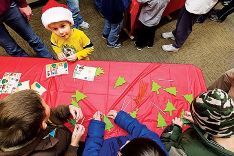 &lt;p&gt;Jaxon Lysne, 4, pauses from putting stickers on a Christmas scene as other children make ornaments during craft activities at the 2012 Post Falls Winterfest.&lt;/p&gt;