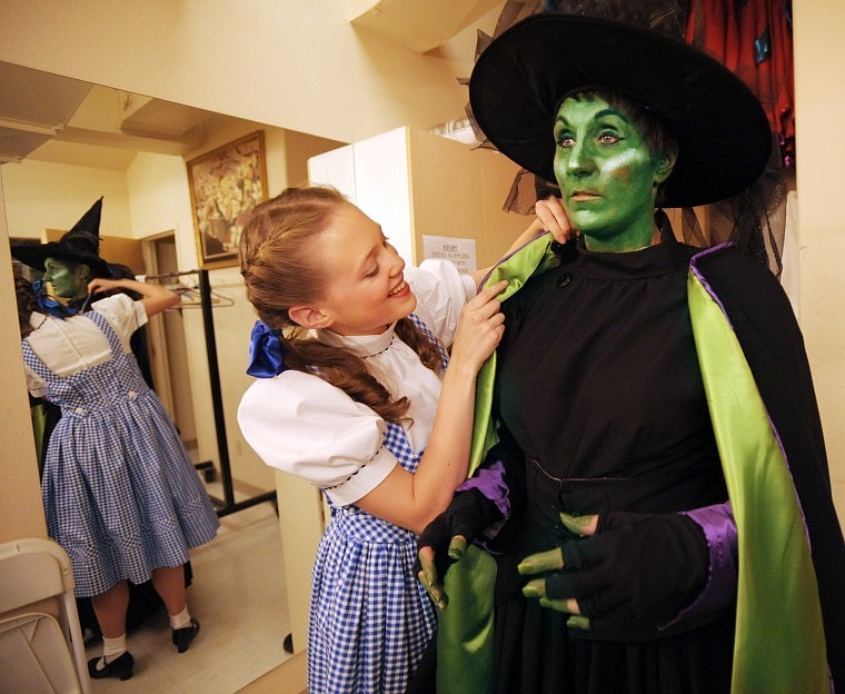 Dorothy (Katie McGunagle) helps the Wicked Witch of the West (Nikki Corne) into her costume.