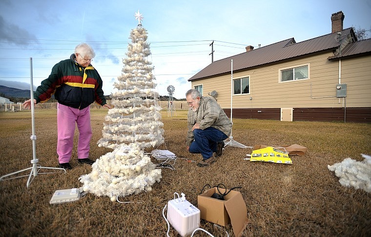 Joan DeRosia and Richard Ortiz of Somers struggle to put up their outside Christmas decorations on Monday. DeRosia said that last year her grandson did this job for them.