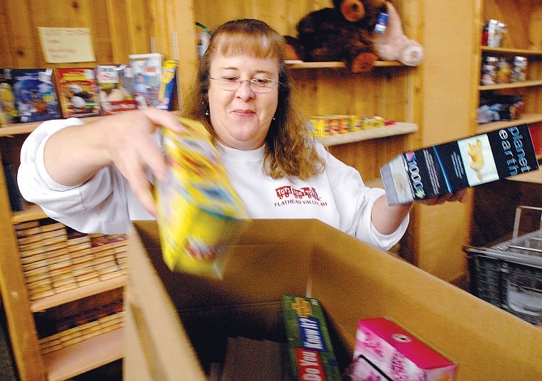 Toys for Tots volunteer Cindy Rogers packs a box full of puzzles, games, and toys at the organization&#146;s storage facility at the Gateway Community Center on Thursday afternoon.