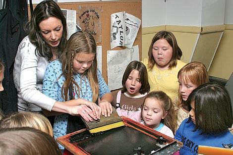 Photos by Sarah Leavenworth&lt;br&gt;Silk screen manager Vanessa Deaton helps Scout Kitiara Hagerman, 10, spread ink over a pattern at Ironhorse Screenworks as (clockwise from back) Shayna Burgess, Colleen Olson, Isabella Richards, Katrina Hagerman and Annie Bright look on. Nine Girl Scouts visited Ironhorse Screenworks in Plains last week.