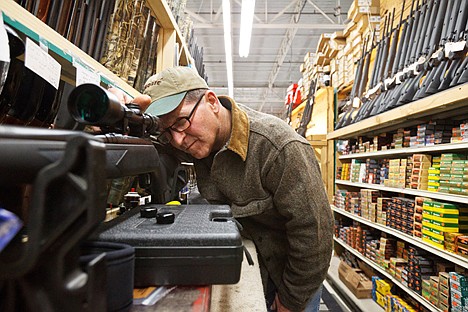 &lt;p&gt;Cory Belt, a sales associate in Black Sheep's gun department, bore sights a scope Monday while preparing a rifle for a customer who was buying the gun as a Christmas gift. Area gun sales are up as the holiday approaches.&lt;/p&gt;